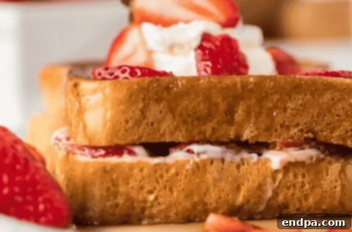 Stuffed French toast on a plate with strawberries.