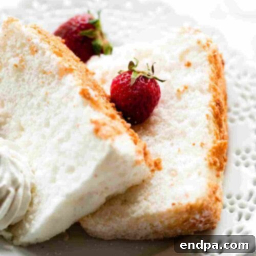 A tall, light, and airy angel food cake slice on a plate.