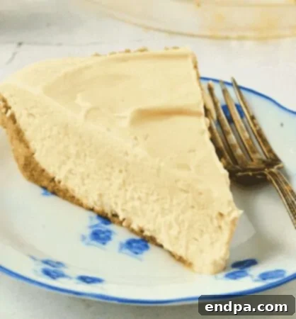 A slice of no-bake vanilla cream pie topped with whipped cream and a cherry.