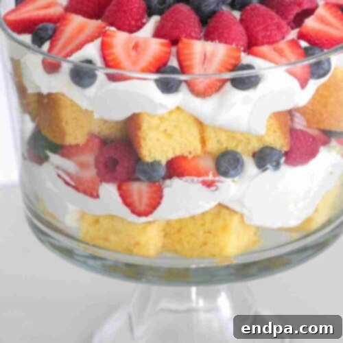 A layered very berry vanilla cake trifle with fresh berries and cream.