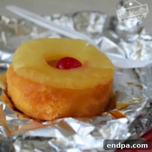Individual Pineapple Upside Down Cakes cooked in foil packets over a campfire.