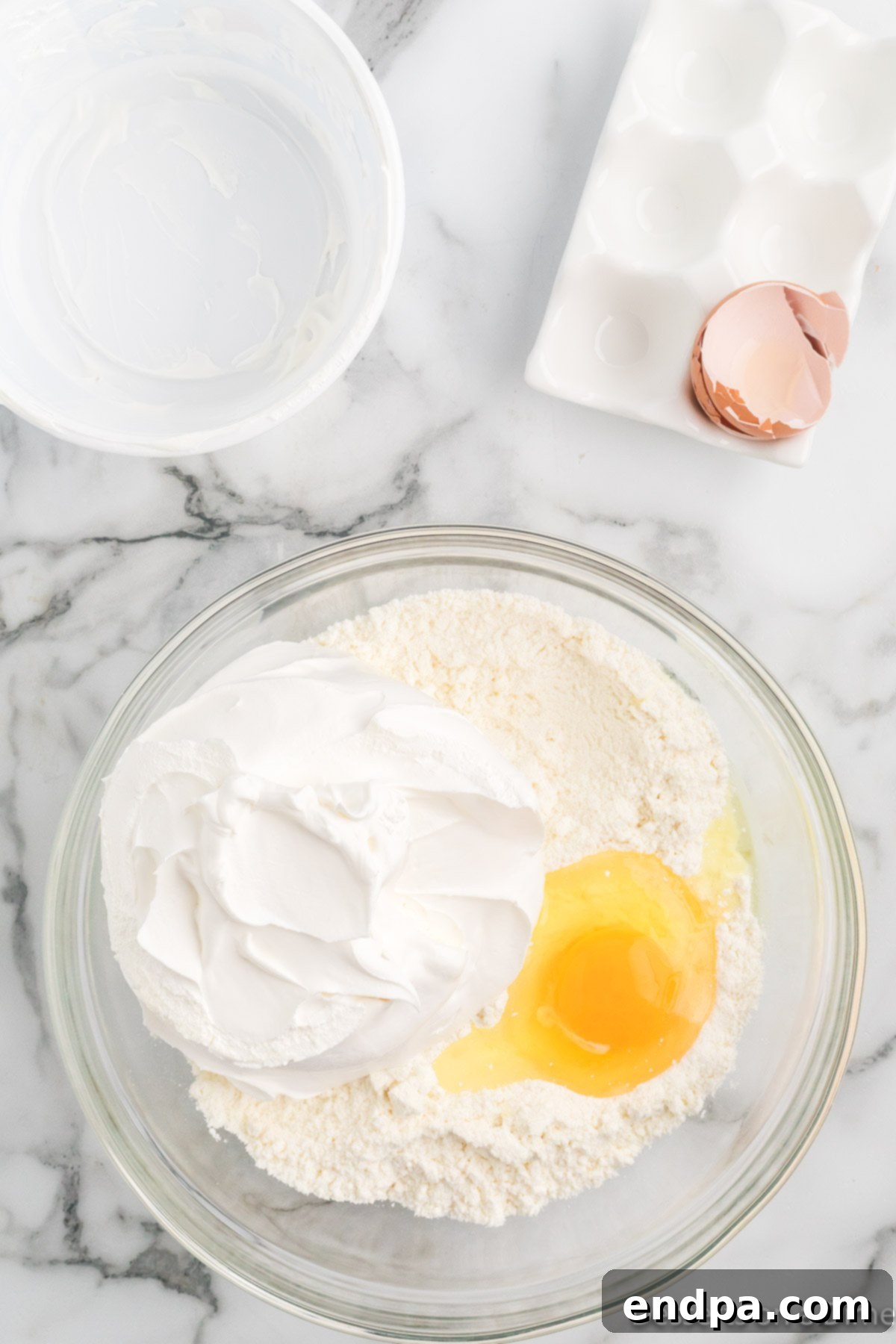 Cool Whip and an egg have been added to the cake mix in the mixing bowl.