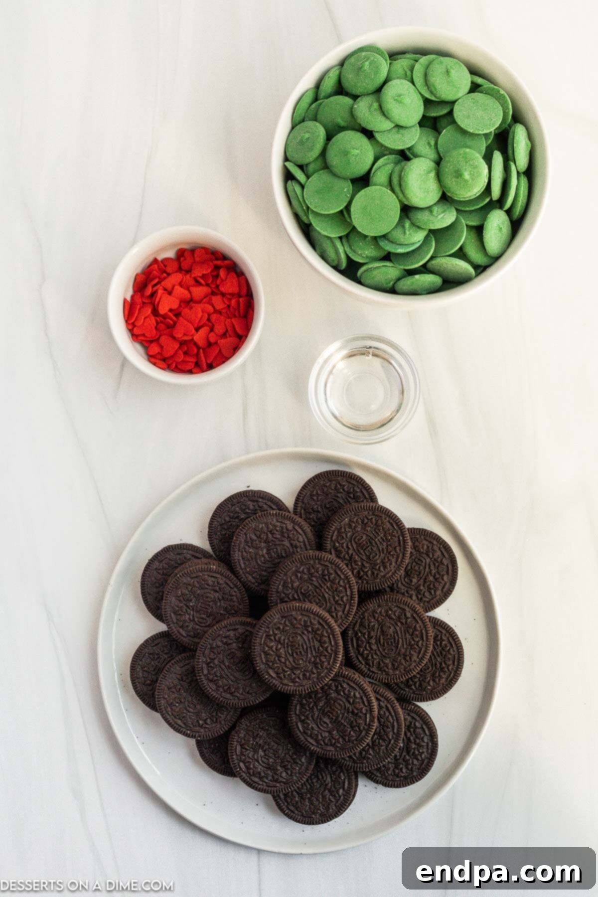 The Grinch's Heart-Melting Oreos 3 The four simple ingredients laid out for making Grinch Oreos: Oreo cookies, green candy melts, coconut oil, and red heart sprinkles.