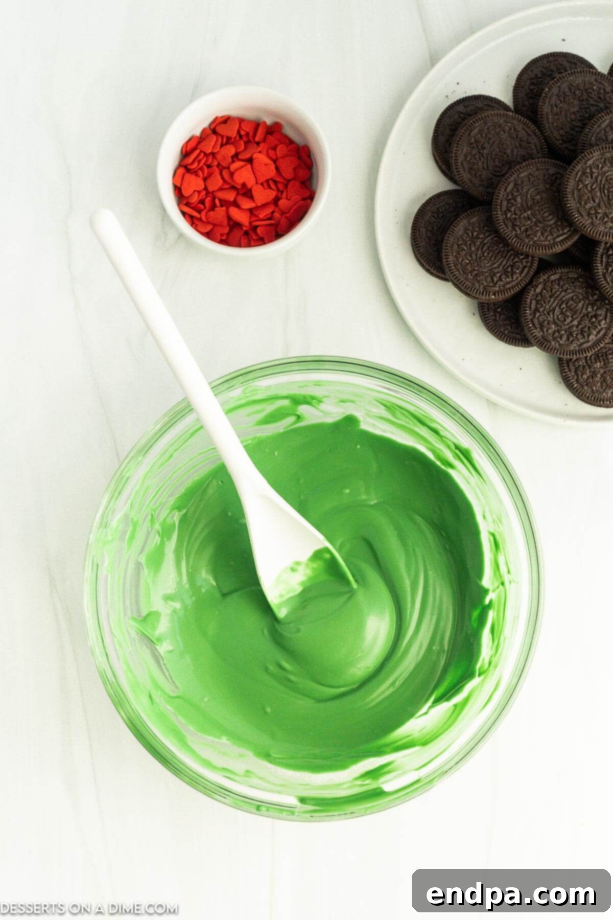 The Grinch's Heart-Melting Oreos 4 A bowl of melted vibrant green candy coating, ready for dipping.