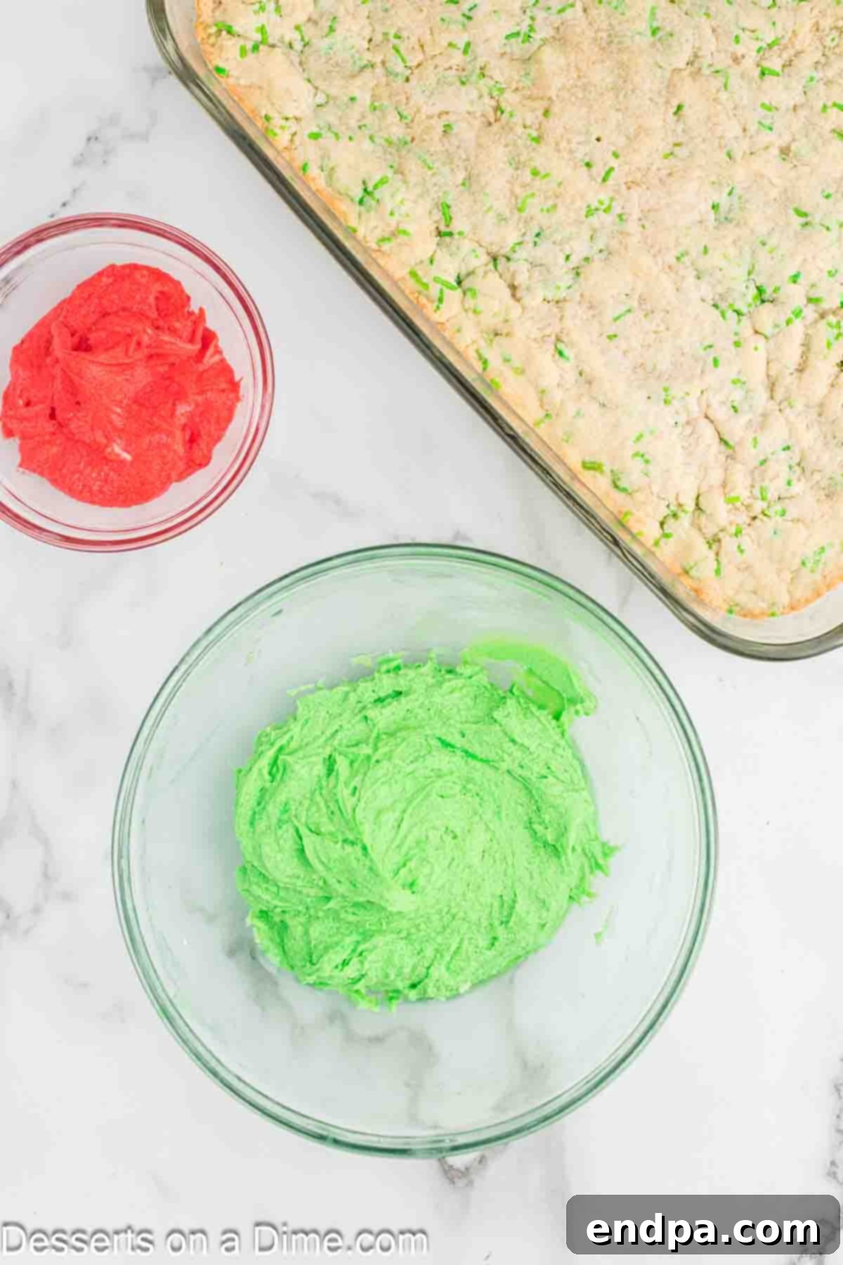 Vibrant green food coloring being mixed into a bowl of creamy frosting for the Grinch theme.