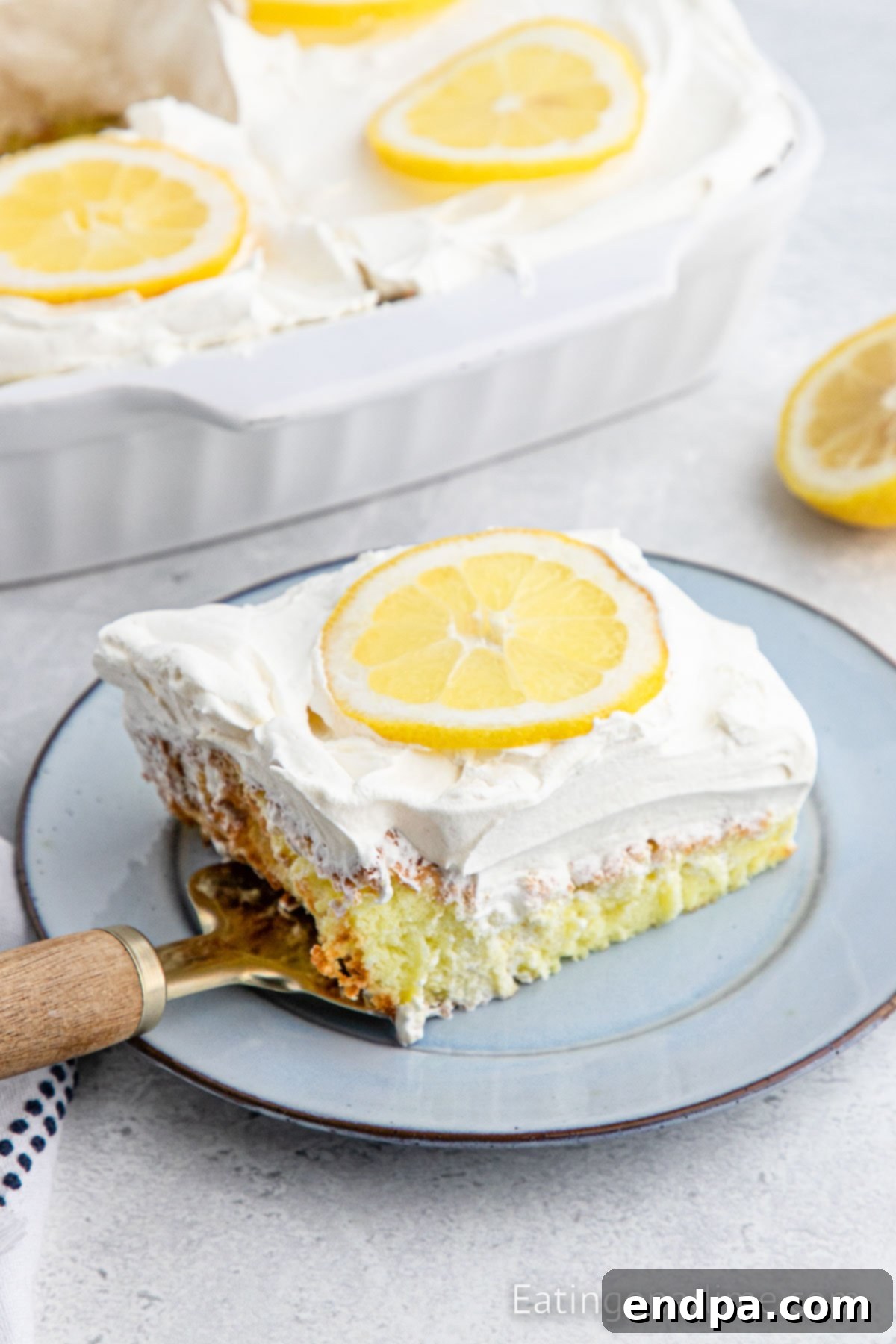 Sunshine Lemon Angel Delight 2 Lemon Angel Food Cake cut and served on a plate, garnished with fresh lemon slices.