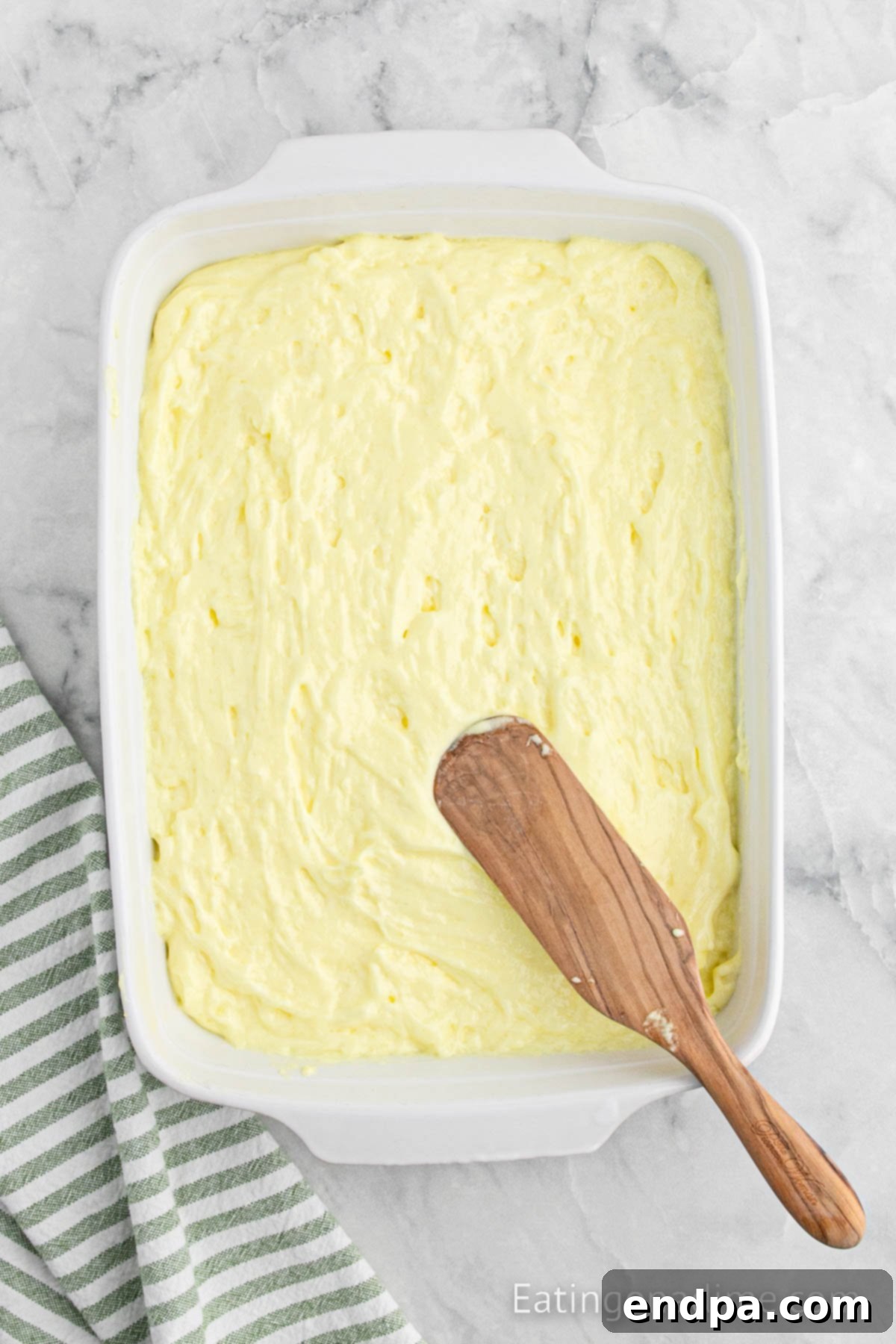 Sunshine Lemon Angel Delight 5 Batter spread into baking dish.