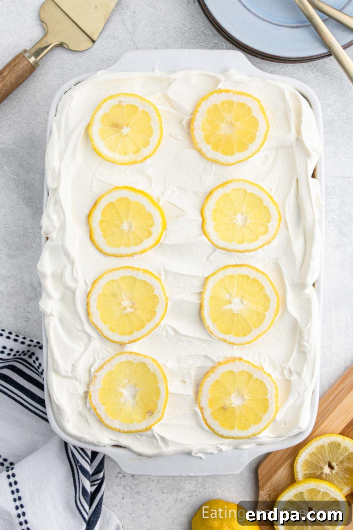 Sunshine Lemon Angel Delight 7 Whipped cream spread on cake and topped with lemon slices.