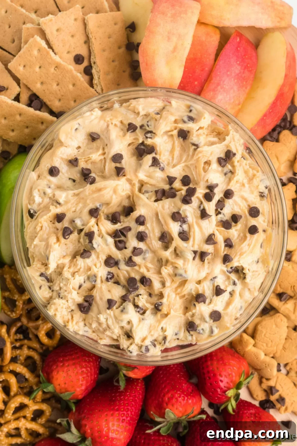Dreamy Peanut Butter Chocolate Dip 2 A beautifully presented bowl of Buckeye Dip, surrounded by a variety of dippers like graham crackers, apple slices, and pretzels, on a rustic platter.