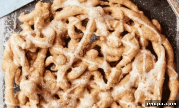 Cinnamon Roll Funnel Cake with cream cheese icing, all the flavors you love.