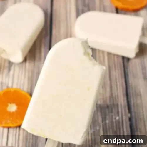 44 Refreshing No-Bake Summer Treats 8 Classic Homemade Orange Creamsicle Popsicle, with a distinct two-tone orange and cream swirl, promising a nostalgic treat.