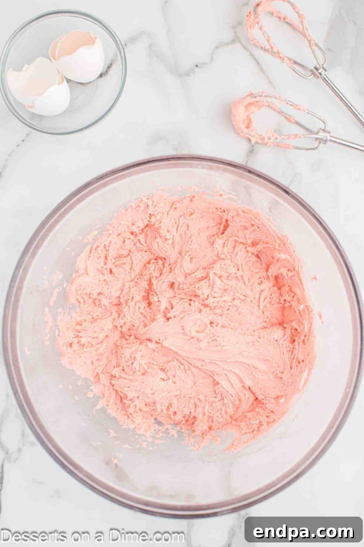Strawberry cake mix, eggs, and oil being mixed together in a large bowl.