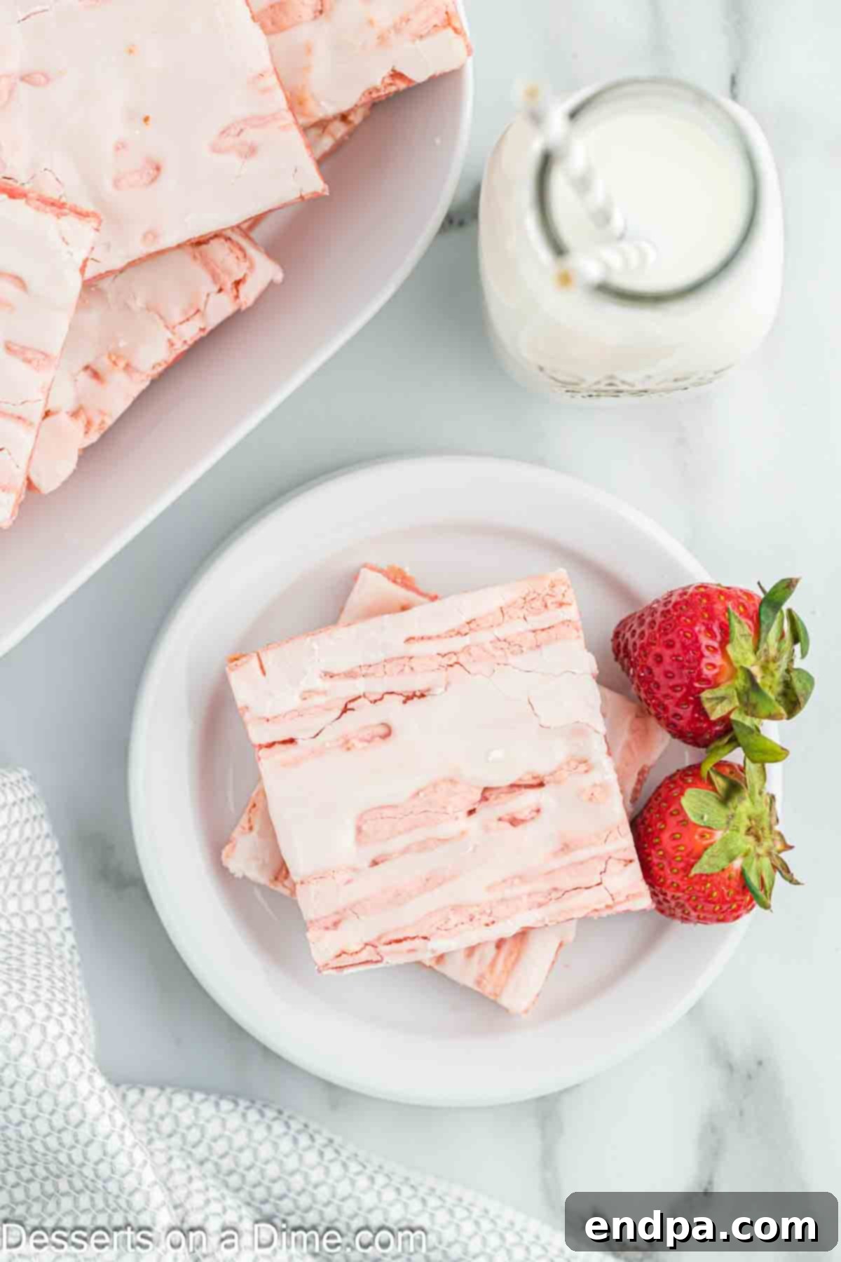 Close-up of strawberry brownies, showing the pink color and glossy glaze, cut into perfect squares.