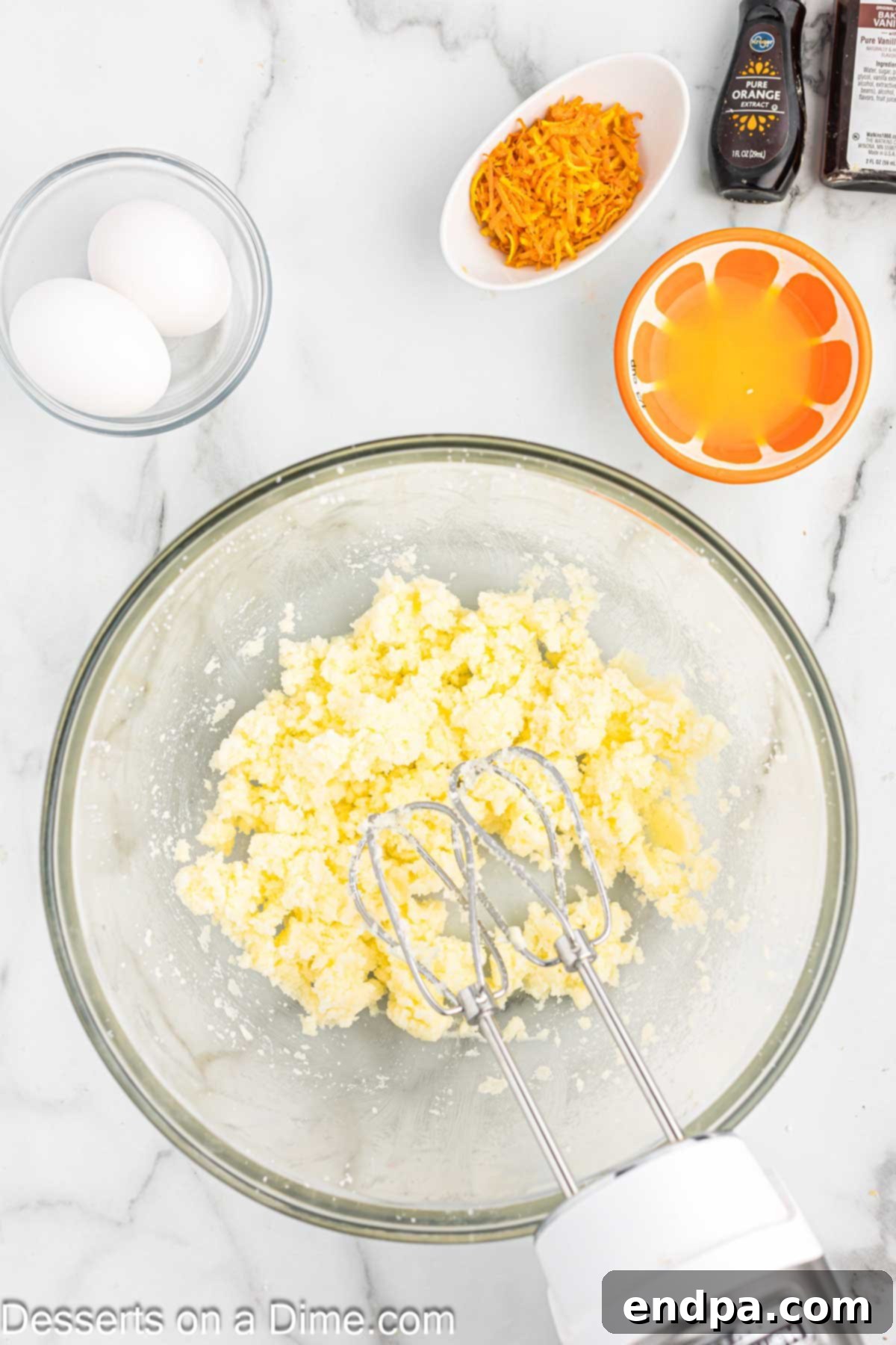 Close-up of butter being creamed in a stand mixer, demonstrating a key step in making orange creamsicle cupcakes.