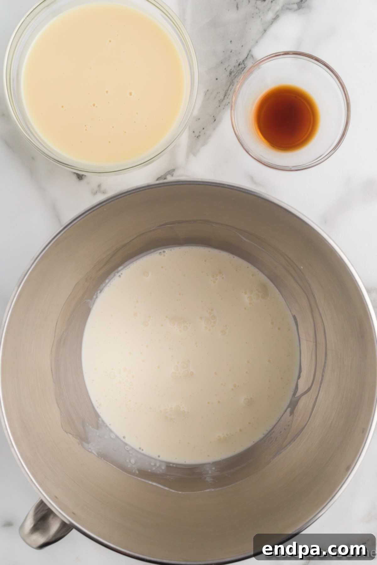 Mixing bowl with sweetened condensed milk, heavy cream and vanilla.