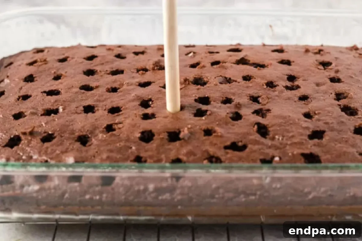 Heavenly Decadence Cake 2 Cake being poked with holes.