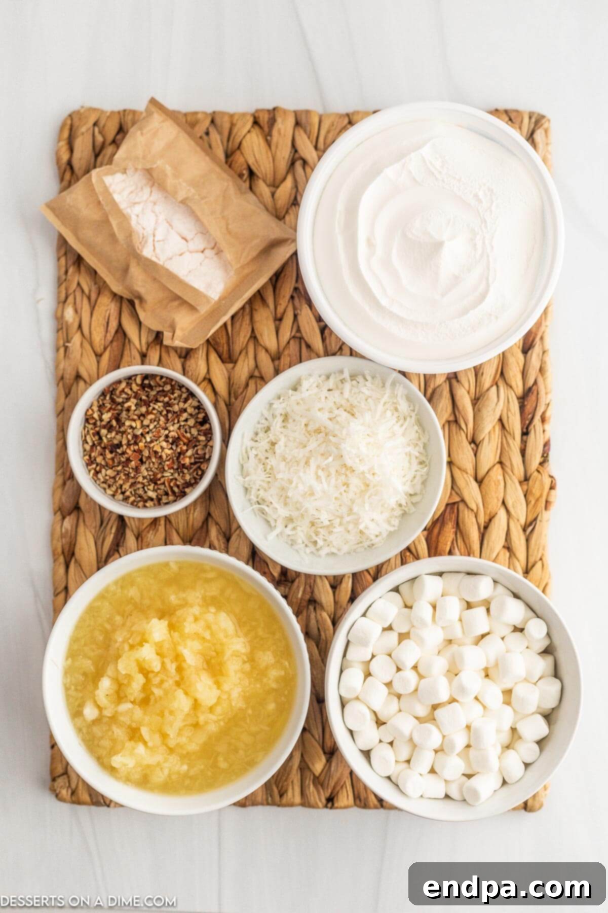 Tropical Pineapple Dream 3 A selection of ingredients for Pineapple Fluff, including instant vanilla pudding mix, crushed pineapple, whipped topping, mini marshmallows, shredded coconut, and chopped pecans.