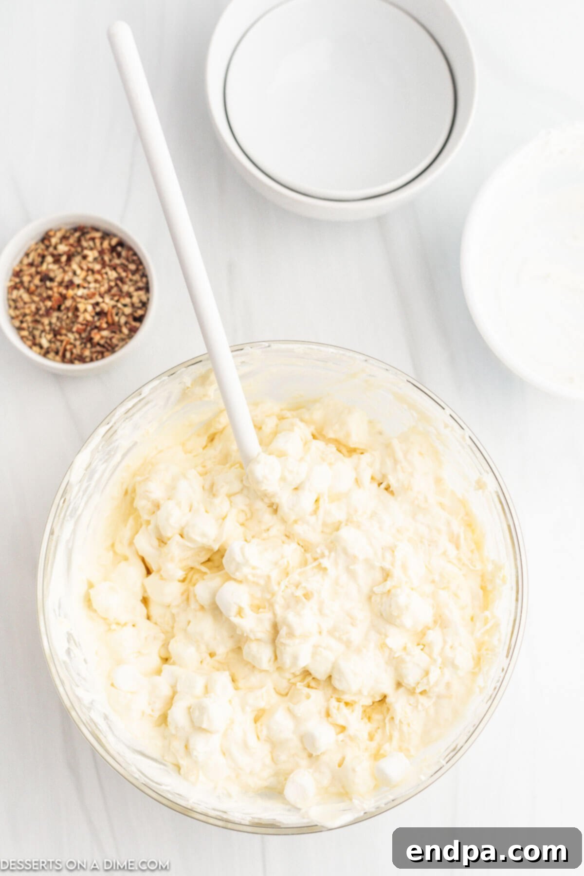 Tropical Pineapple Dream 6 Mini marshmallows and shredded coconut being folded into the pineapple fluff mixture.