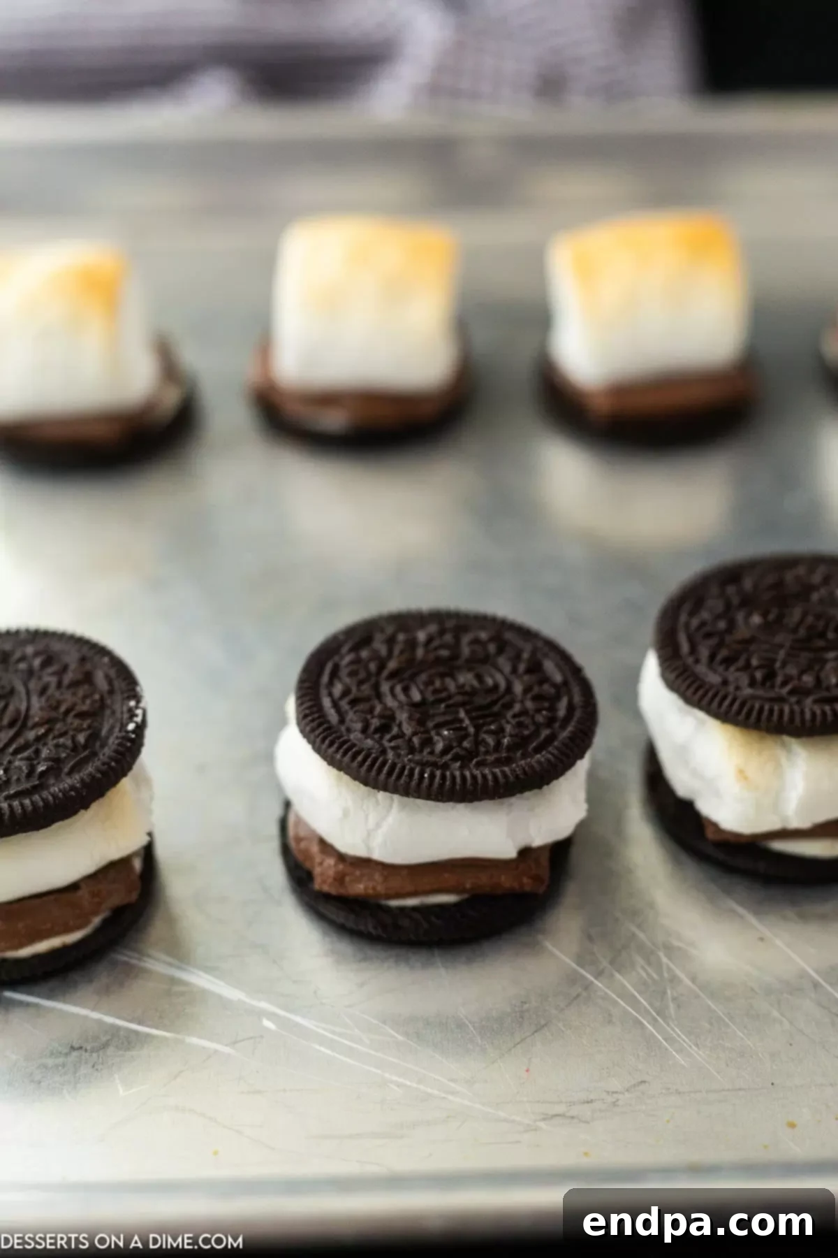 Oreo S'mores Dream 7 Completed Oreo s'mores with a plain Oreo half placed on top, ready to be enjoyed.