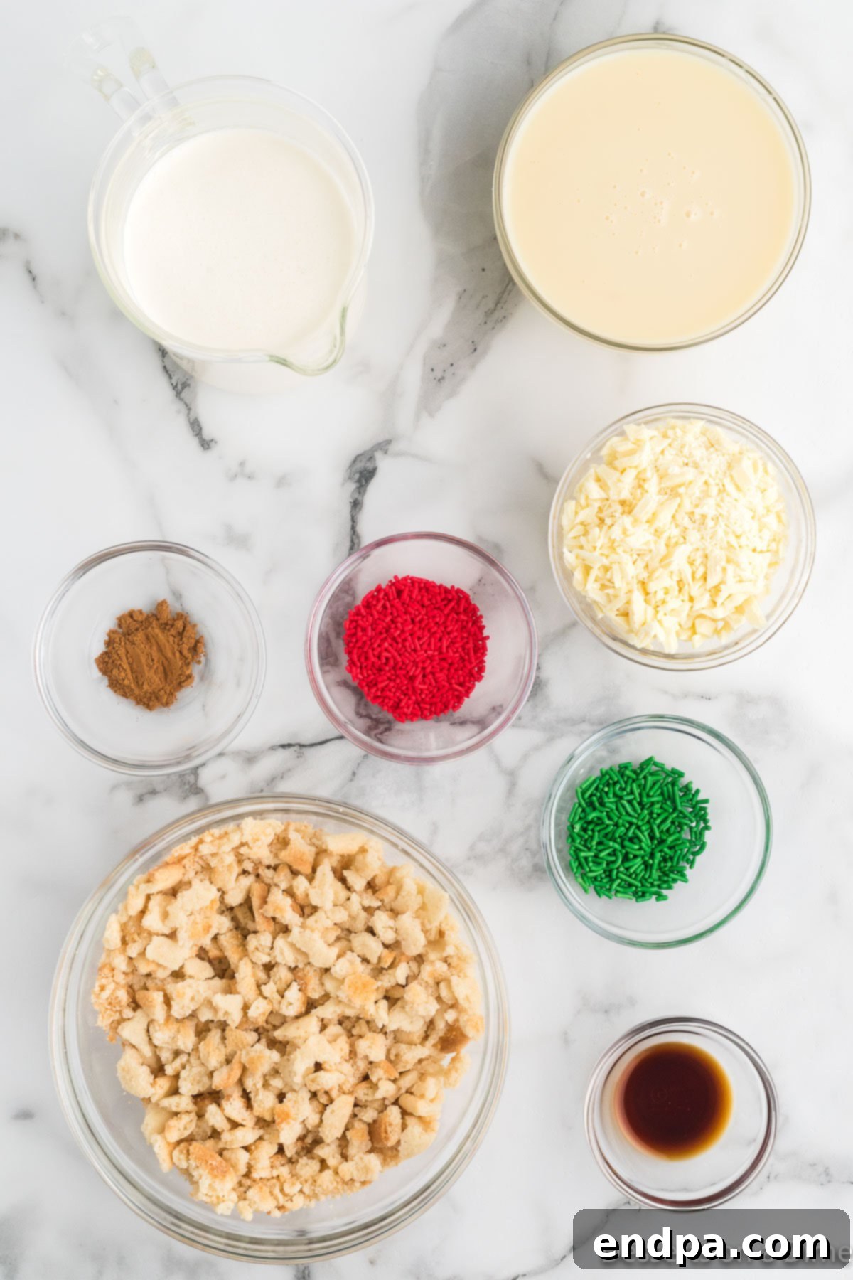 Merry Melts 3 A flat lay photograph showcasing all the ingredients required for the Christmas Ice Cream recipe: heavy whipping cream, sweetened condensed milk, vanilla extract, ground cinnamon, sugar cookies, white chocolate, and an assortment of red and green sprinkles.