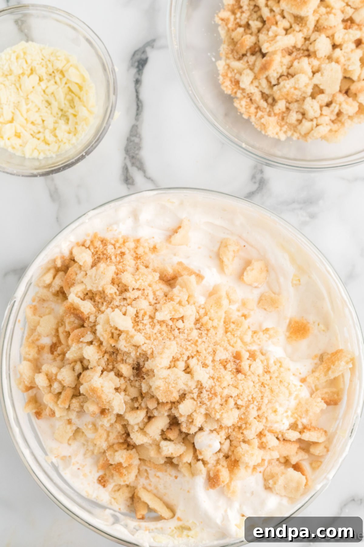 Merry Melts 8 Crumbled sugar cookies and finely chopped white chocolate being folded into the ice cream base.