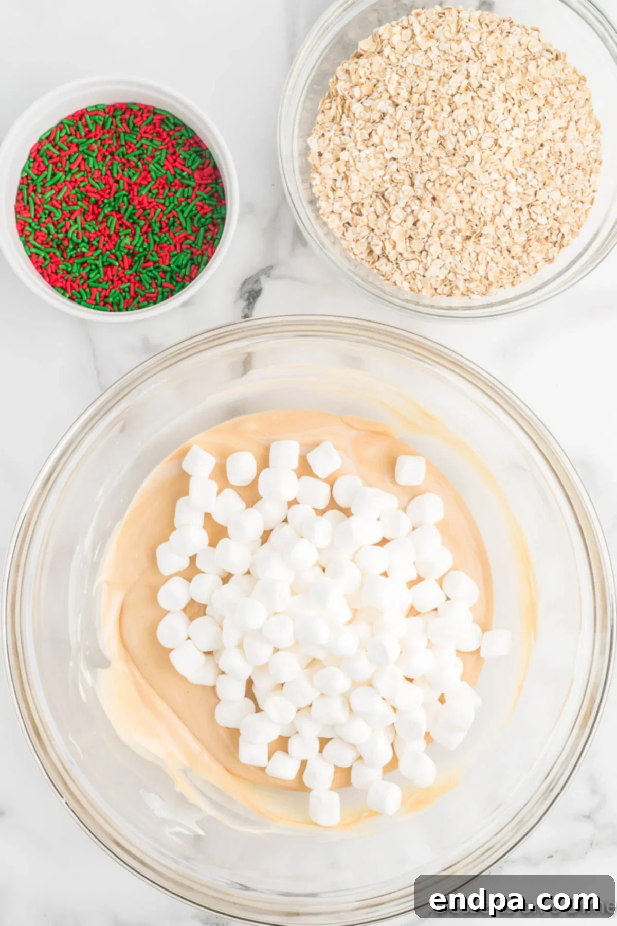 Festive No-Bake Delights 6 Quick oats, mini marshmallows, and half of the sprinkles being gently folded into the chocolate peanut butter mixture.