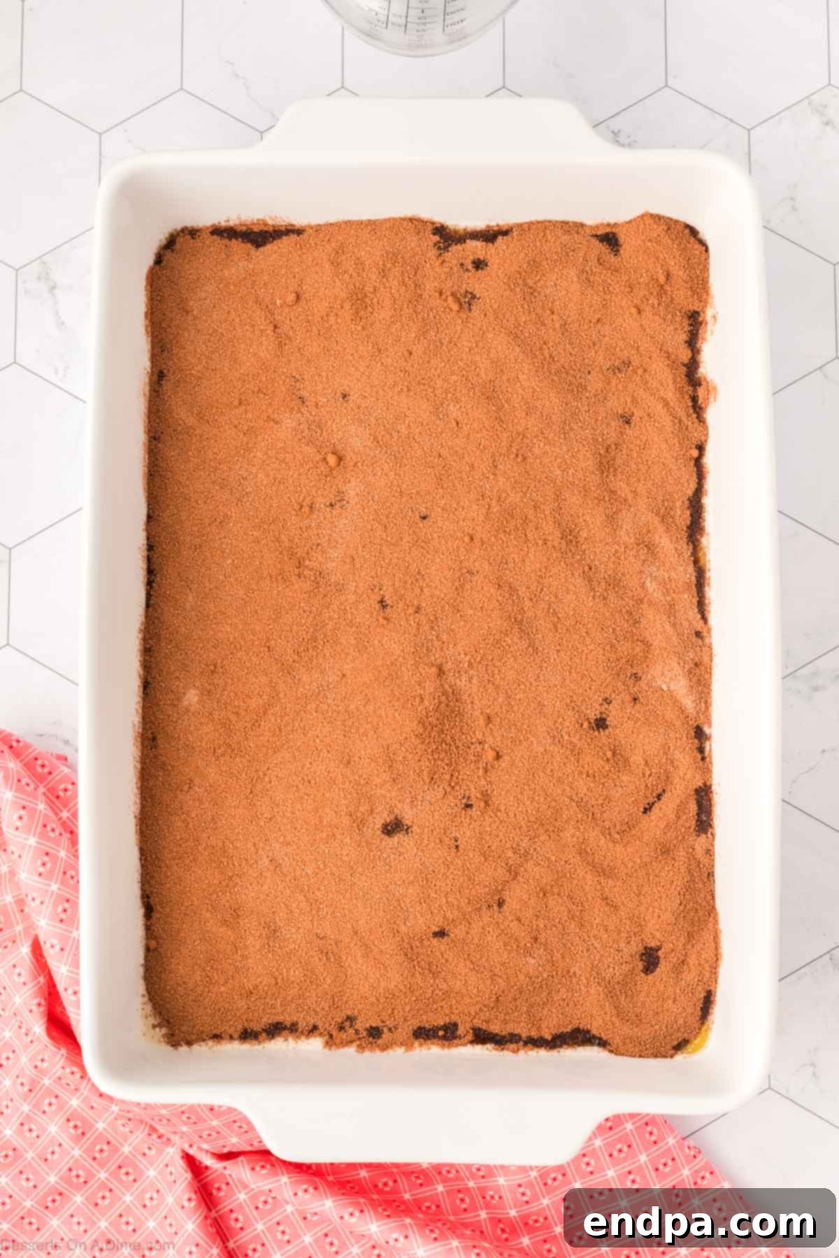 Topping the flour mixture with the cocoa mixture in the baking dish