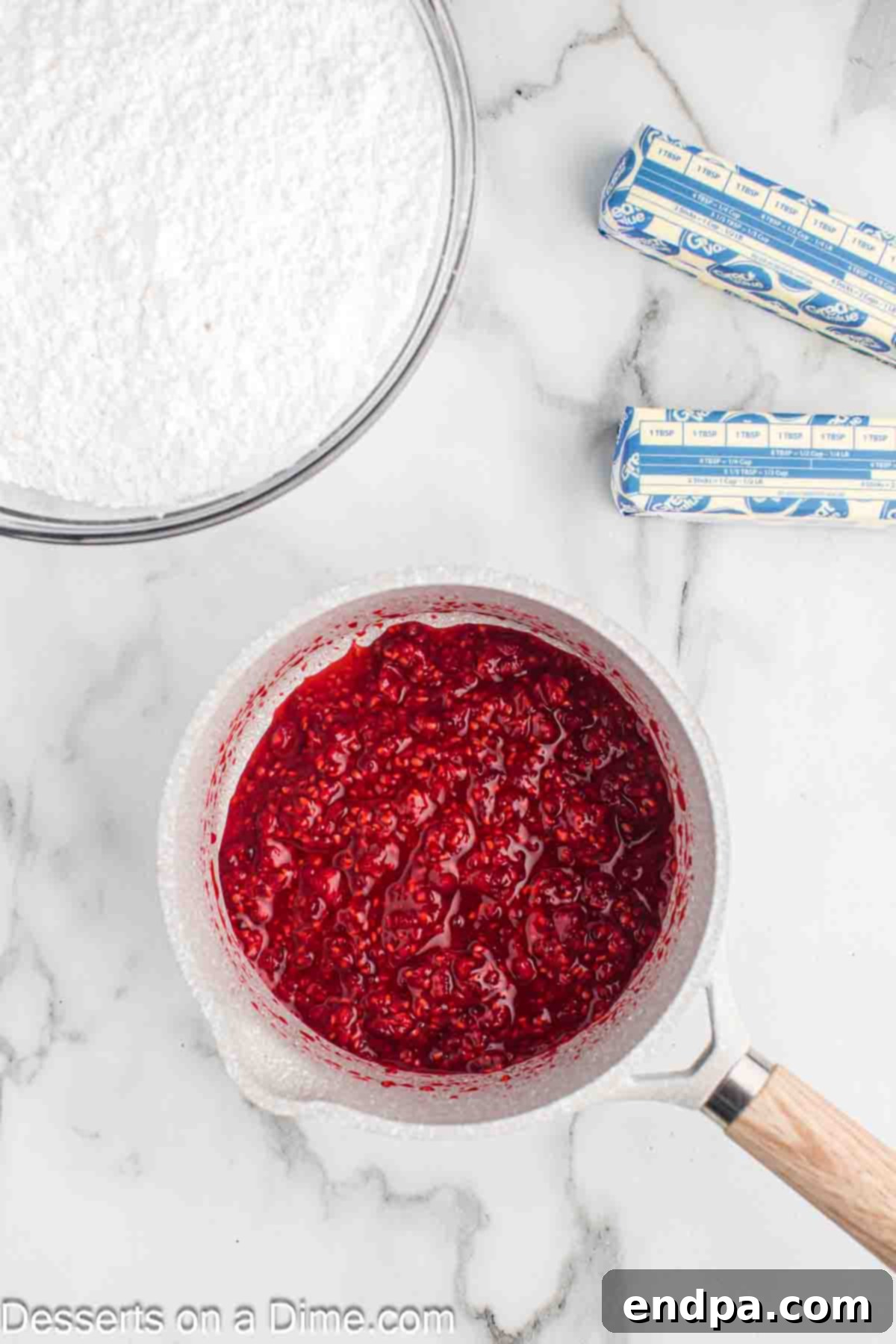 Fresh raspberries in a small saucepan over a stove burner.