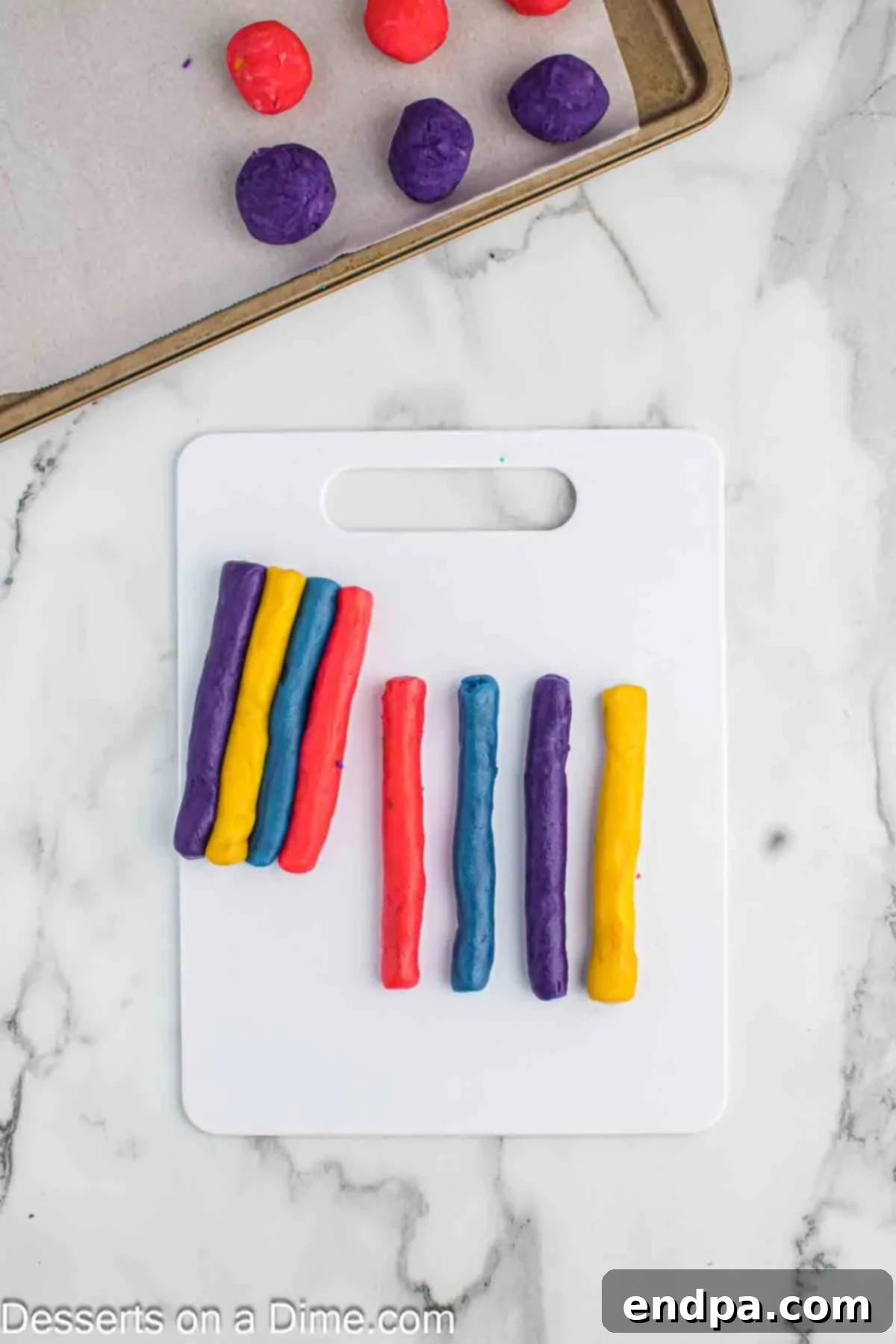 Rainbow Unicorn Drops 9 Strips of colorful cookie dough rolled out like snakes, ready to be stacked and swirled.