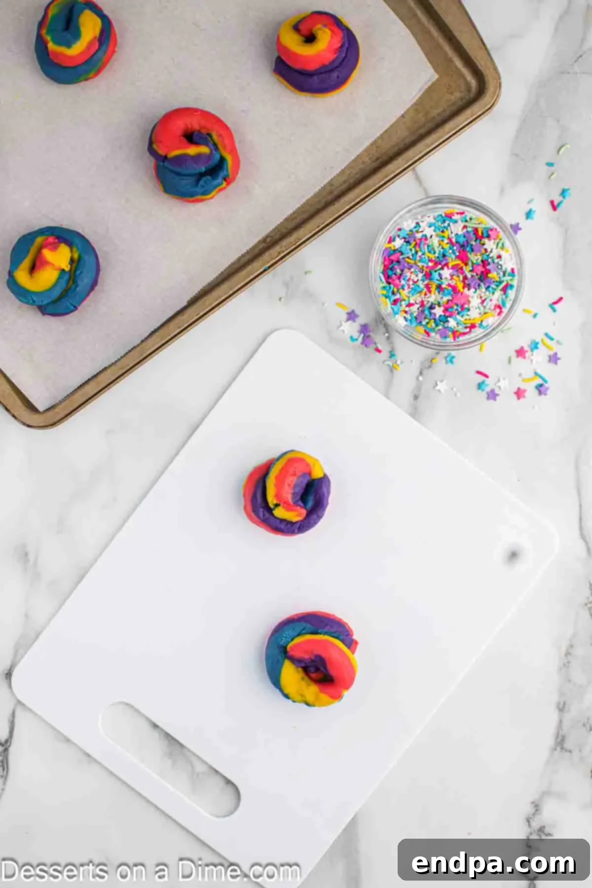 Rainbow Unicorn Drops 10 Colorful dough ropes stacked, gently pressed, and swirled into whimsical cookie shapes before baking.
