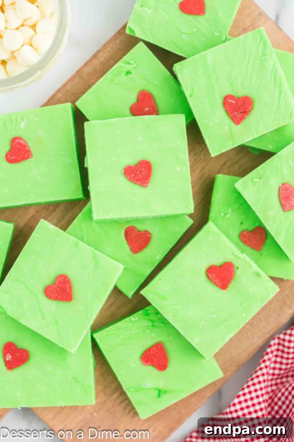 Grinch Fudge cut into neat bars, showcasing its vibrant green color and red heart sprinkles.