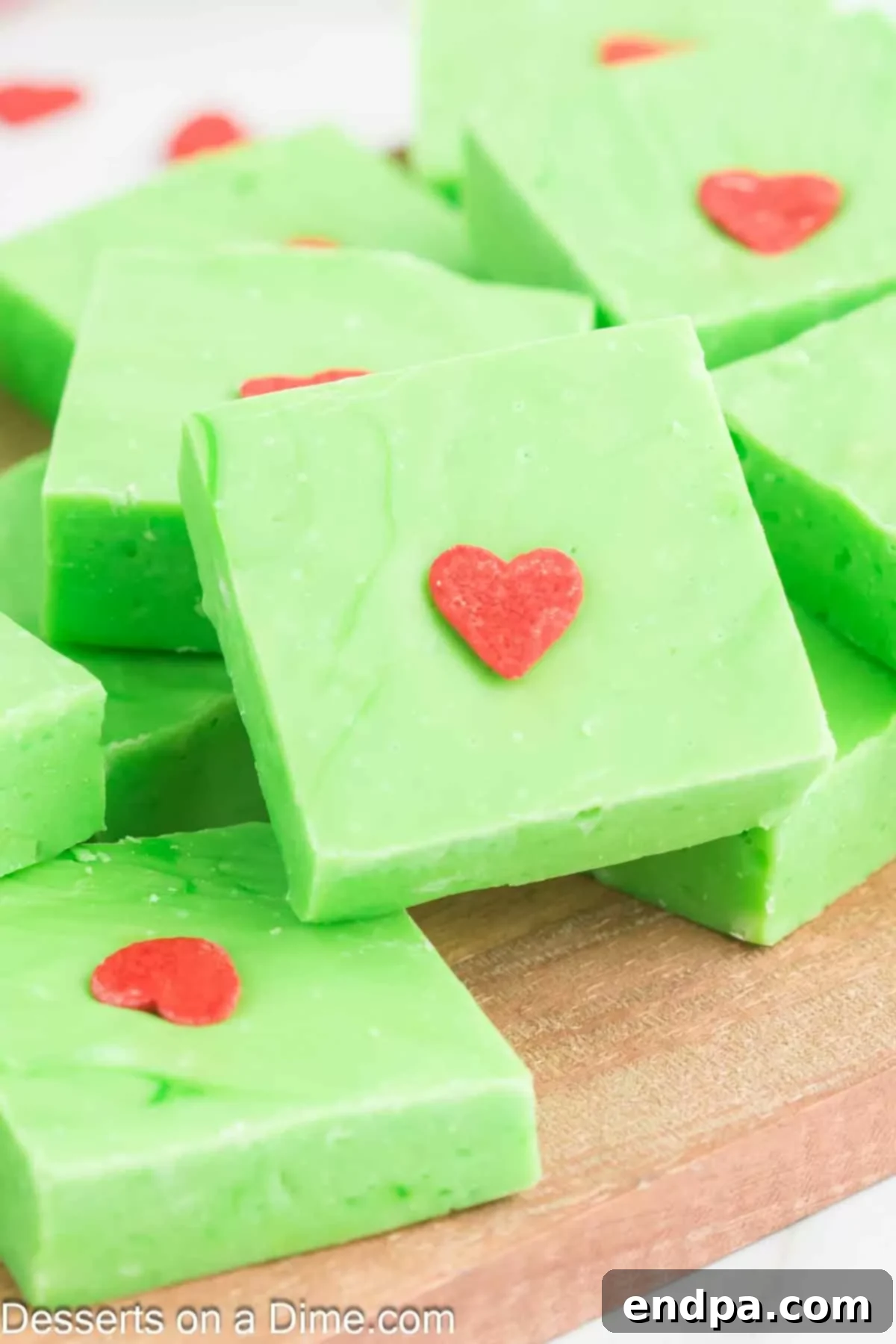 Grinch Fudge cut into neat, square bars on a cutting board, ready for serving.