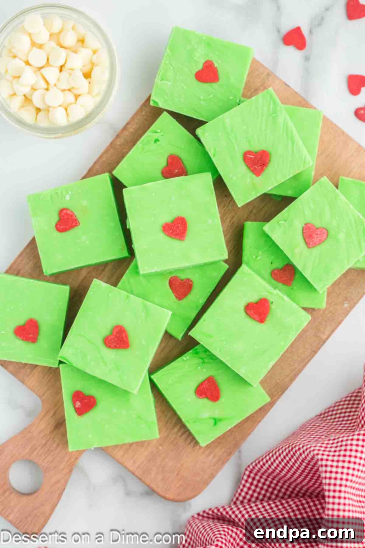 Grinch Fudge cut into bars, stacked on a wooden cutting board, ready for serving.