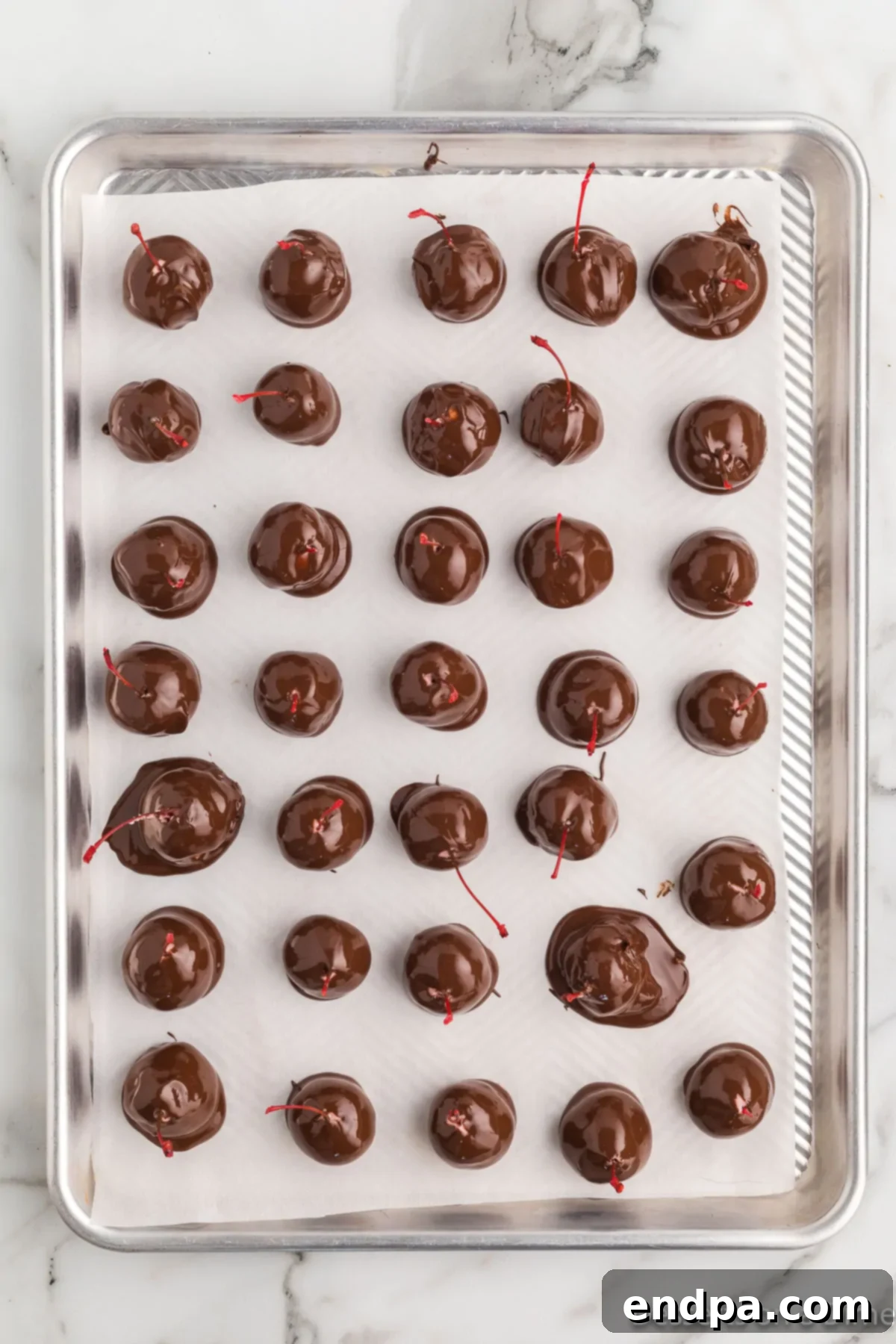 Chocolate covered cherries on baking sheet. 