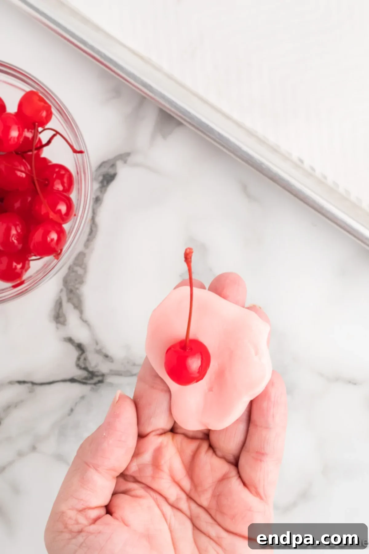 Dough flattened and cherry placed inside. 