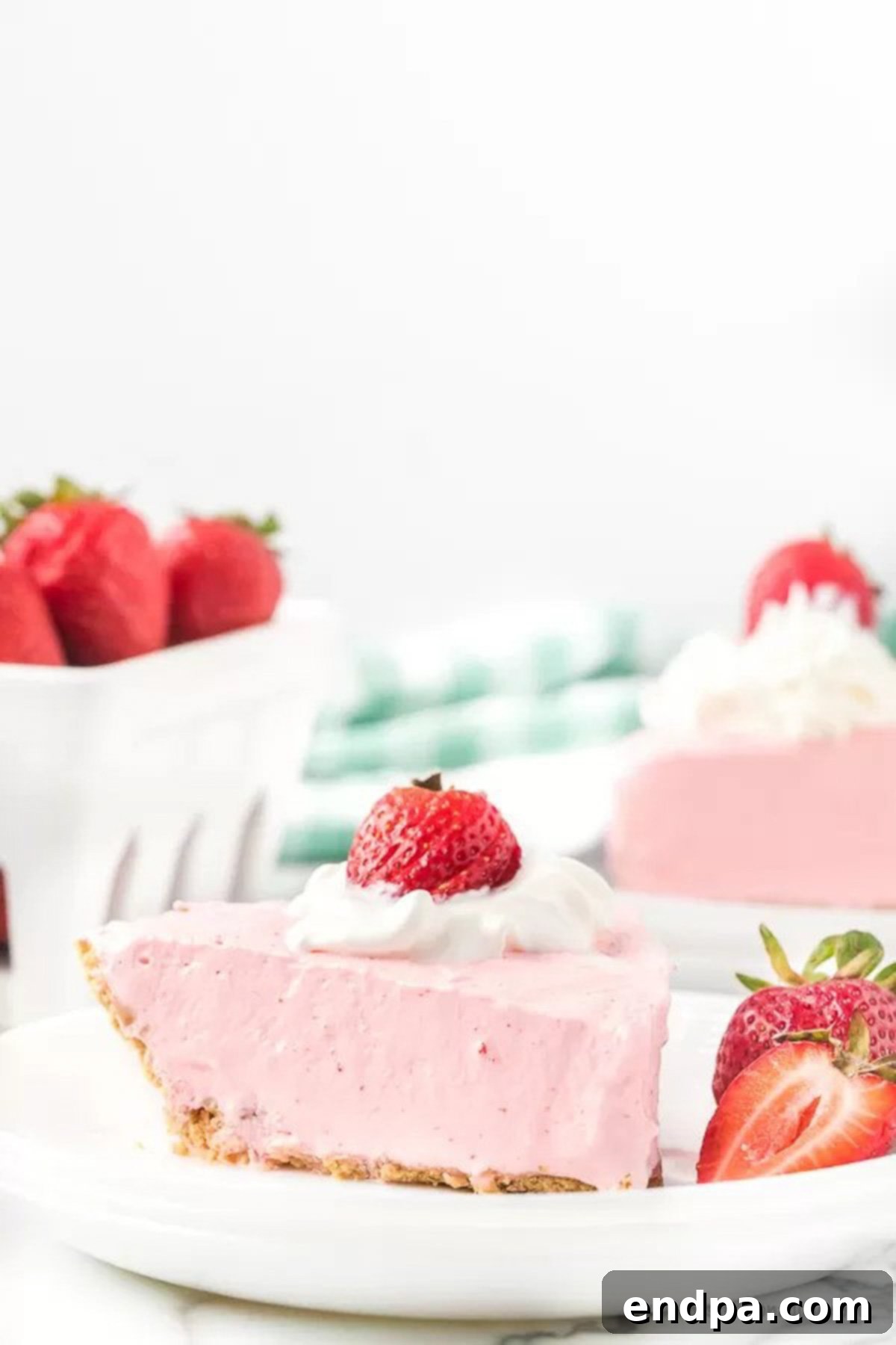A slice of Strawberry Jello pie on a white plate with a fork, ready to eat