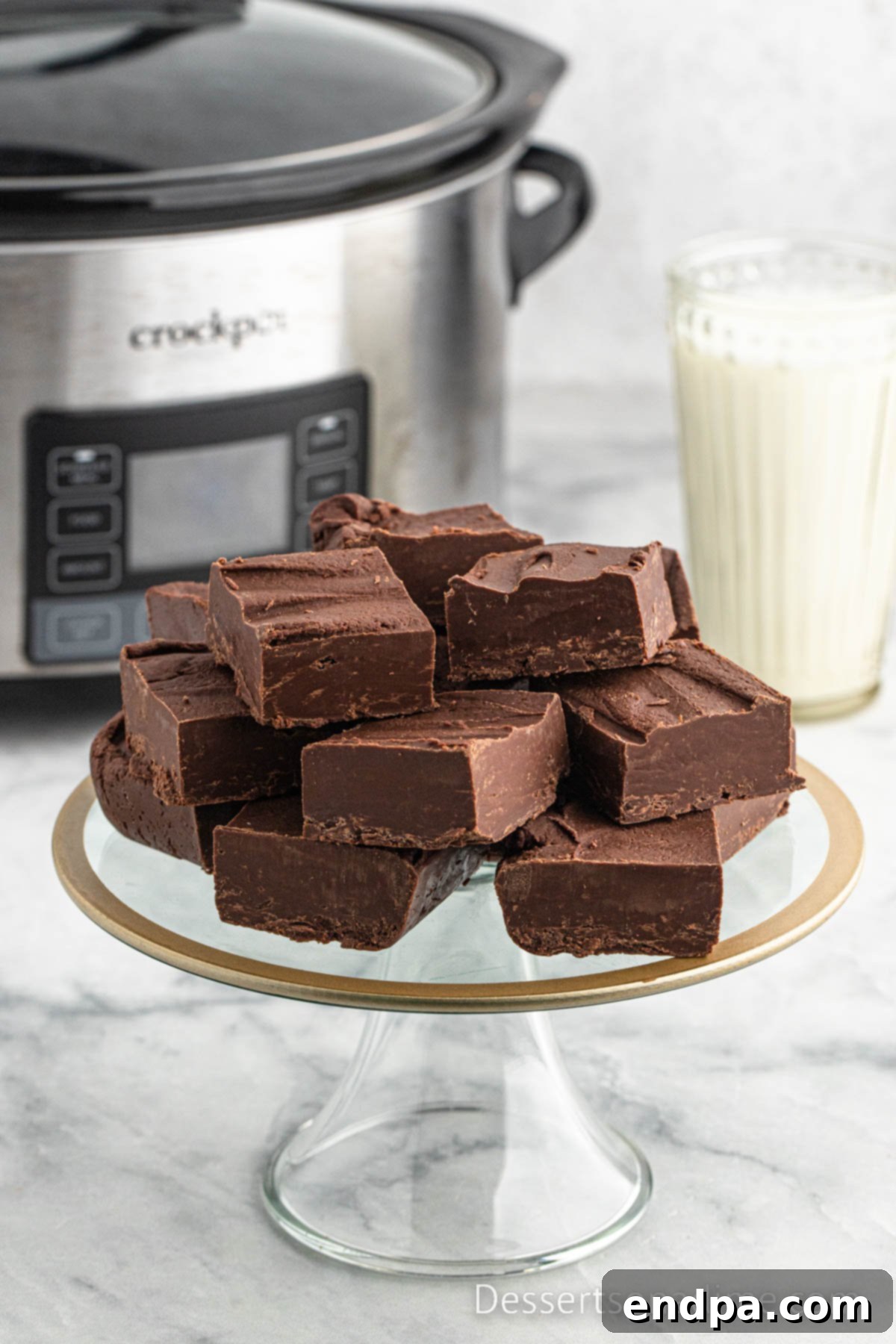 Crock Pot Fudge on a dessert stand, cut into perfect squares.