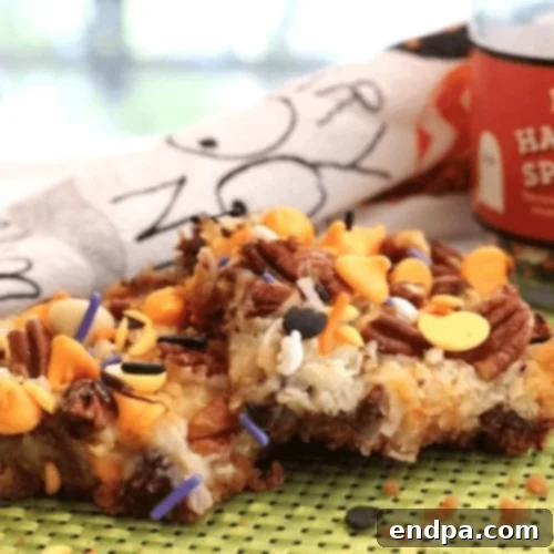 Wickedly Wonderful Halloween Cookie Ideas 13 Magic Cookie Bars layered with graham cracker crumbs, coconut, pecans, chocolate chips, and Halloween sprinkles
