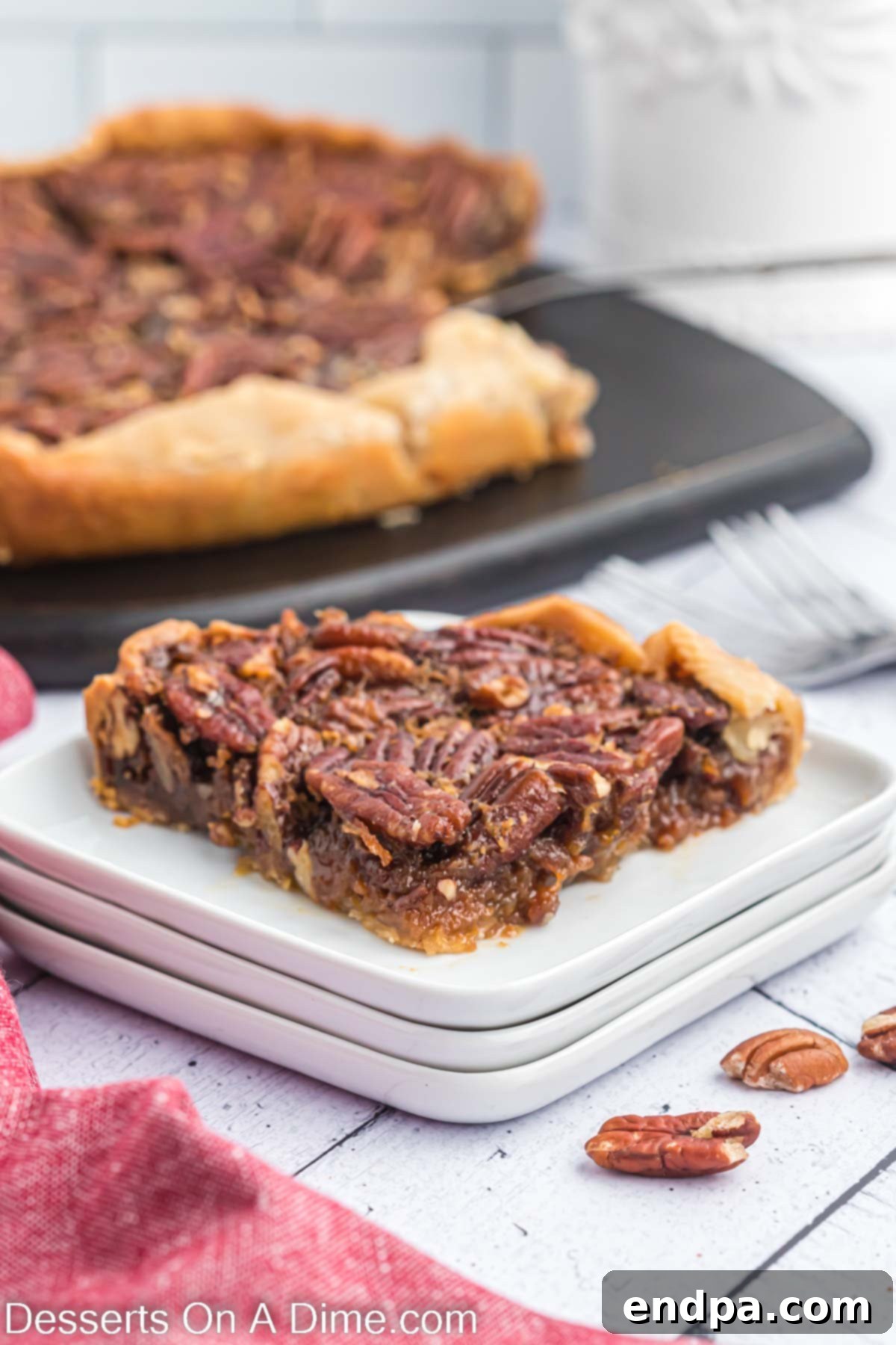 How to Freeze Pecan Pie 2 A perfectly baked slice of pecan pie, glistening with its rich filling and topped with whole pecans, rests on a white plate, inviting a delicious bite.