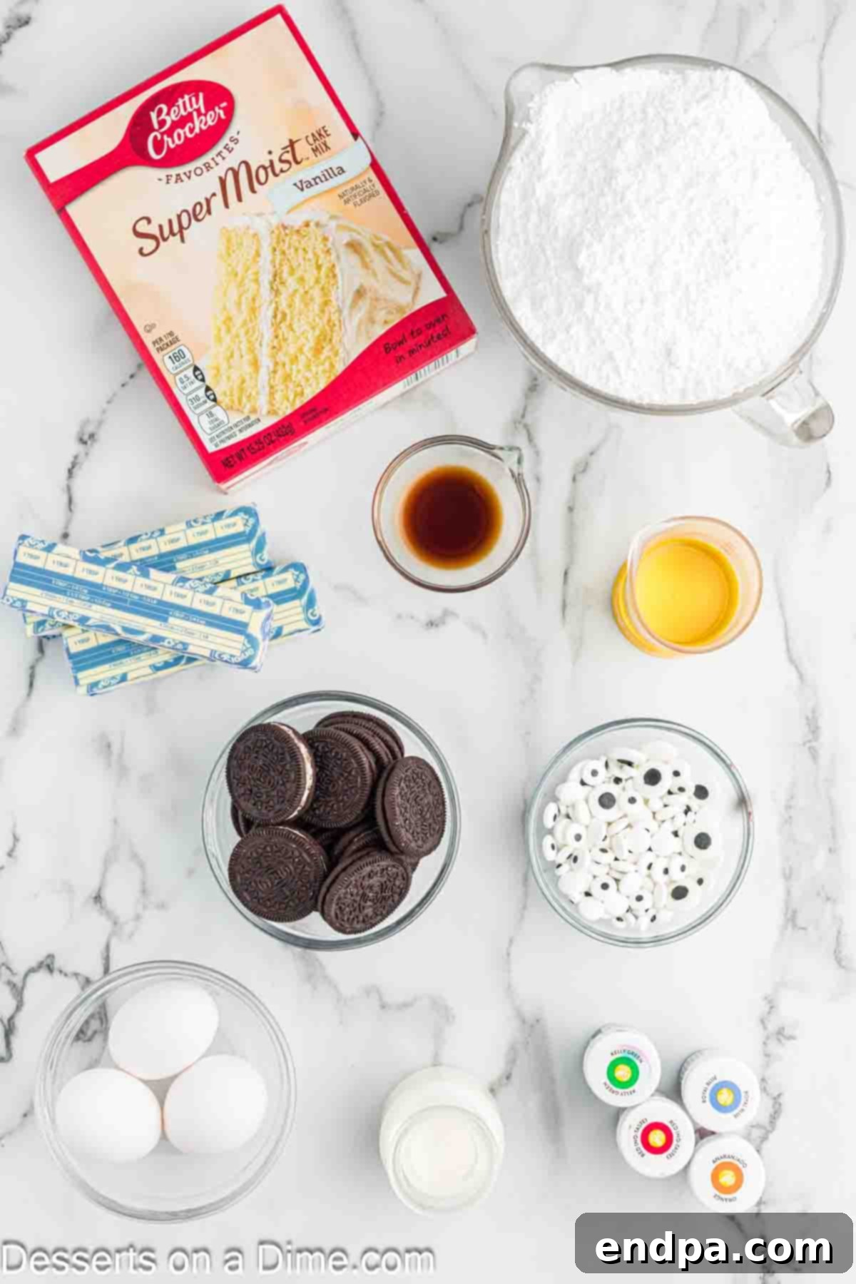 Spooktacular Monster Cupcakes 3 Ingredients for Monster Cupcakes laid out: vanilla cake mix, butter, powdered sugar, heavy cream, gel food coloring, candy eyeballs, oreo cookies.