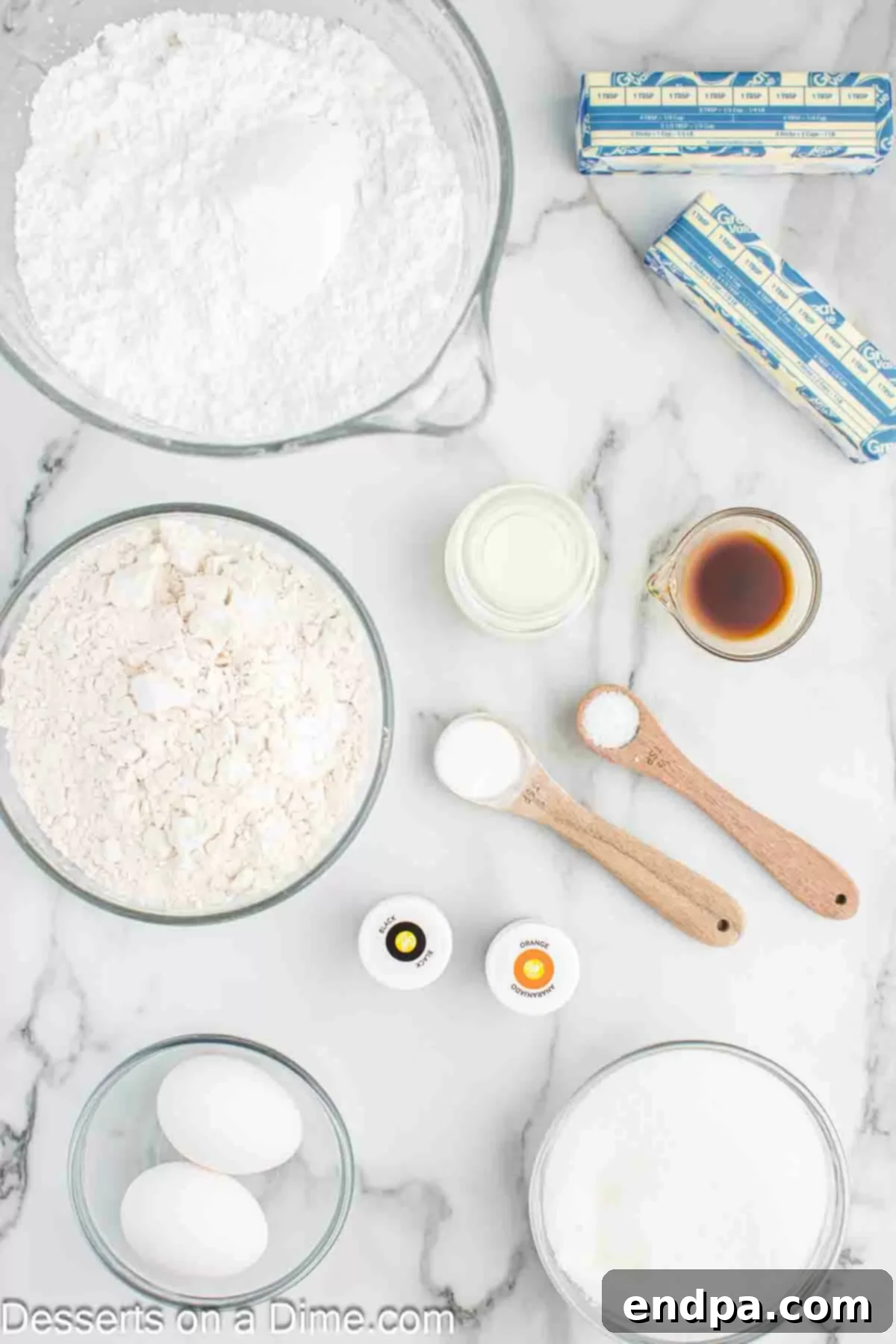 Frightfully Delicious Halloween Cookies 3 A flat lay of ingredients for Halloween sugar cookies including flour, butter, sugar, eggs, vanilla, powdered sugar, milk, and food coloring.