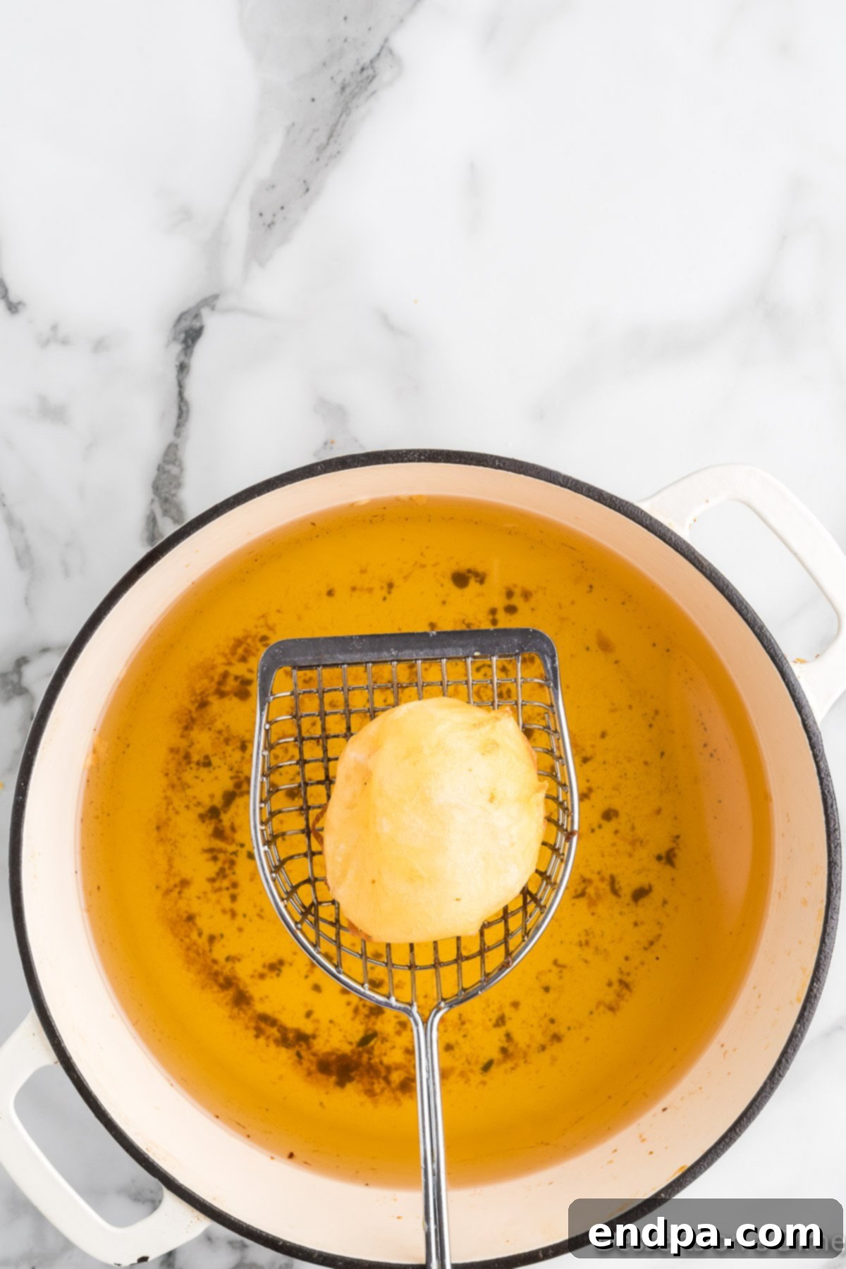Fried Marshmallow on slotted spoon. 