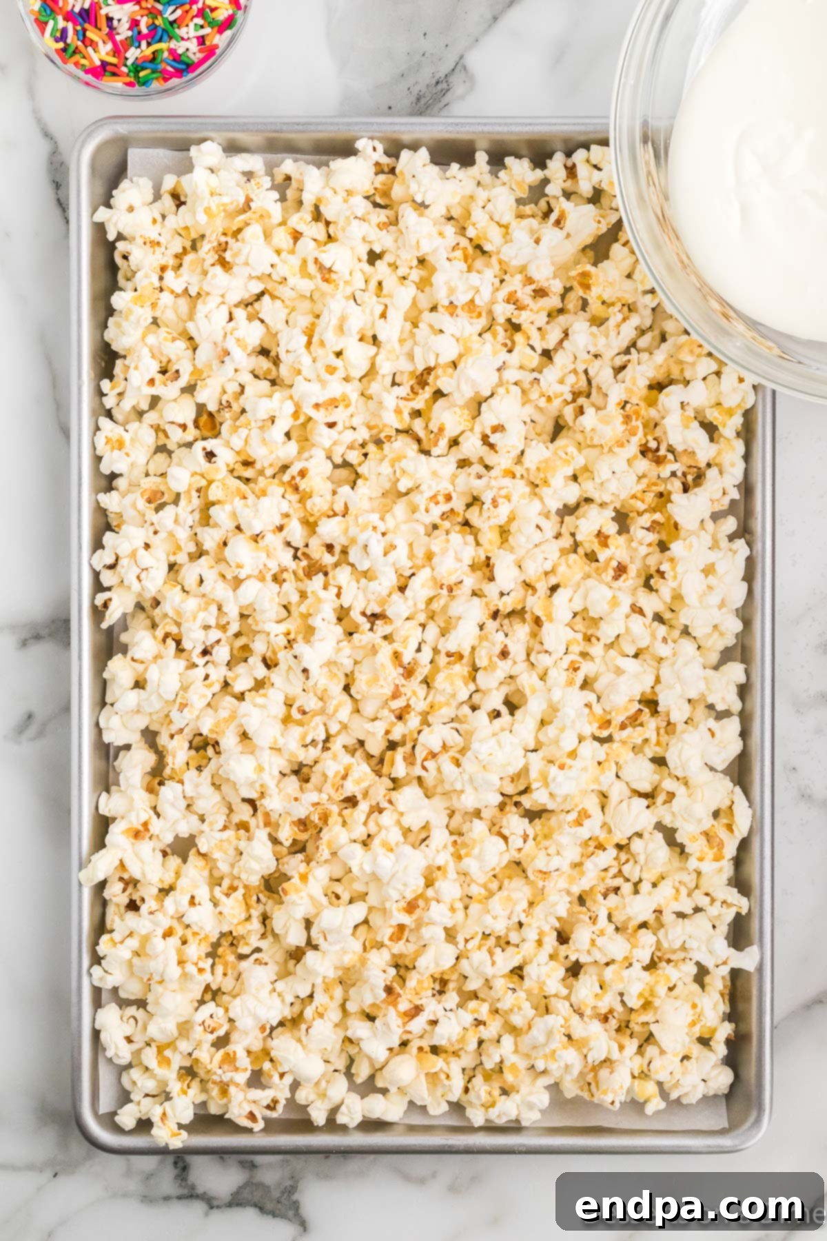 Bakery Sweet Popcorn 7 Melted candy melts poured over popcorn on pan.