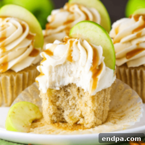 Sweet Caramel Apple Cupcakes topped with a drizzle of caramel.