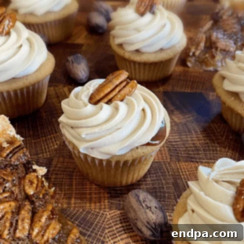 Delightful Pecan Pie Filled Cupcakes topped with frosting and pecans.