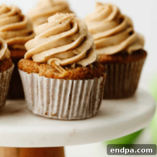 Scrumptious Apple Pie Cupcakes with a dollop of frosting and apple filling.