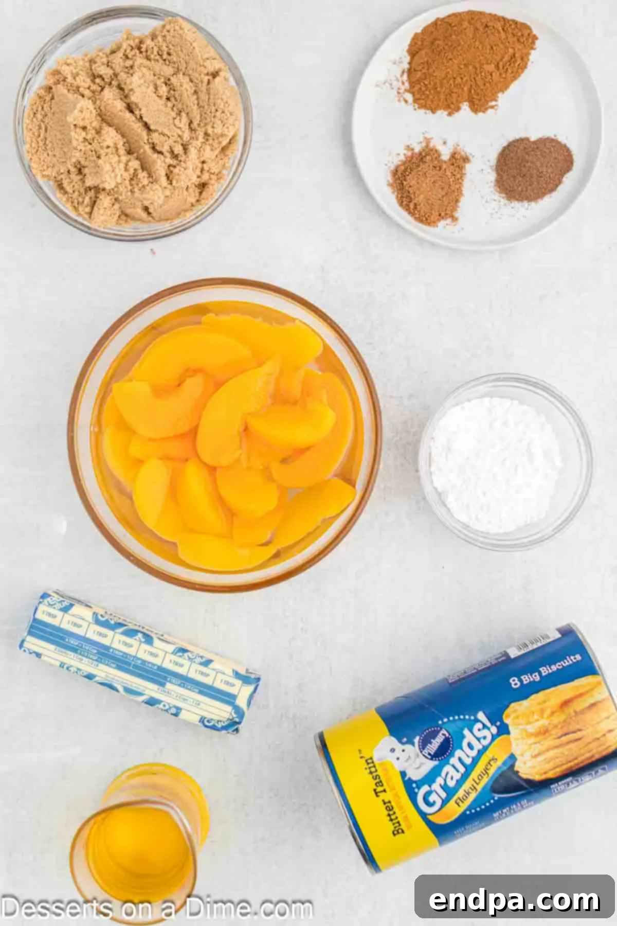 Ingredients for Fried Peach Cobbler: canned peaches in syrup, brown sugar, ground cinnamon, nutmeg, allspice, butter, flaky layered biscuits, powdered sugar, and a scoop of vanilla ice cream.