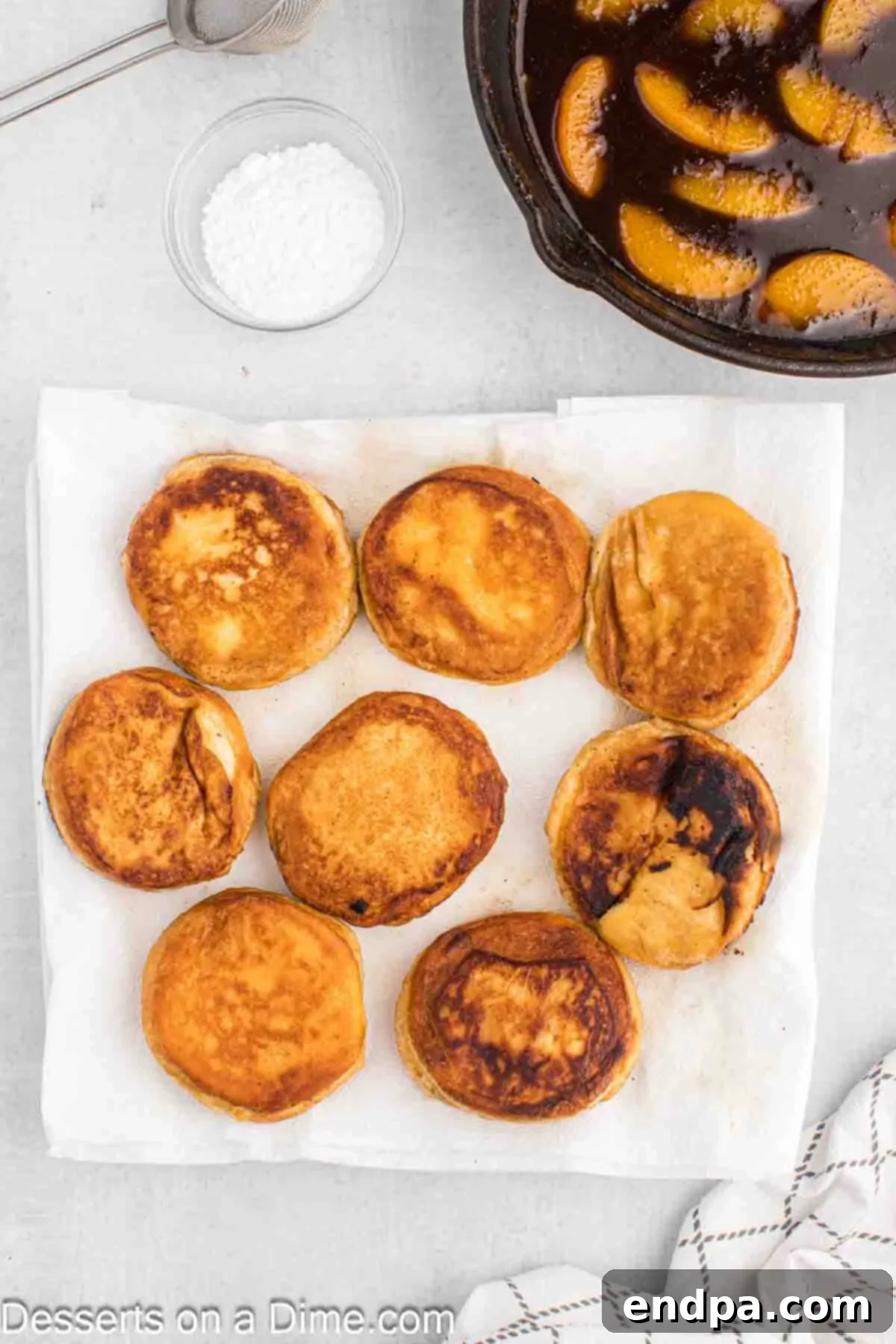 Golden brown fried biscuits cooling on a plate lined with paper towels to absorb excess oil.