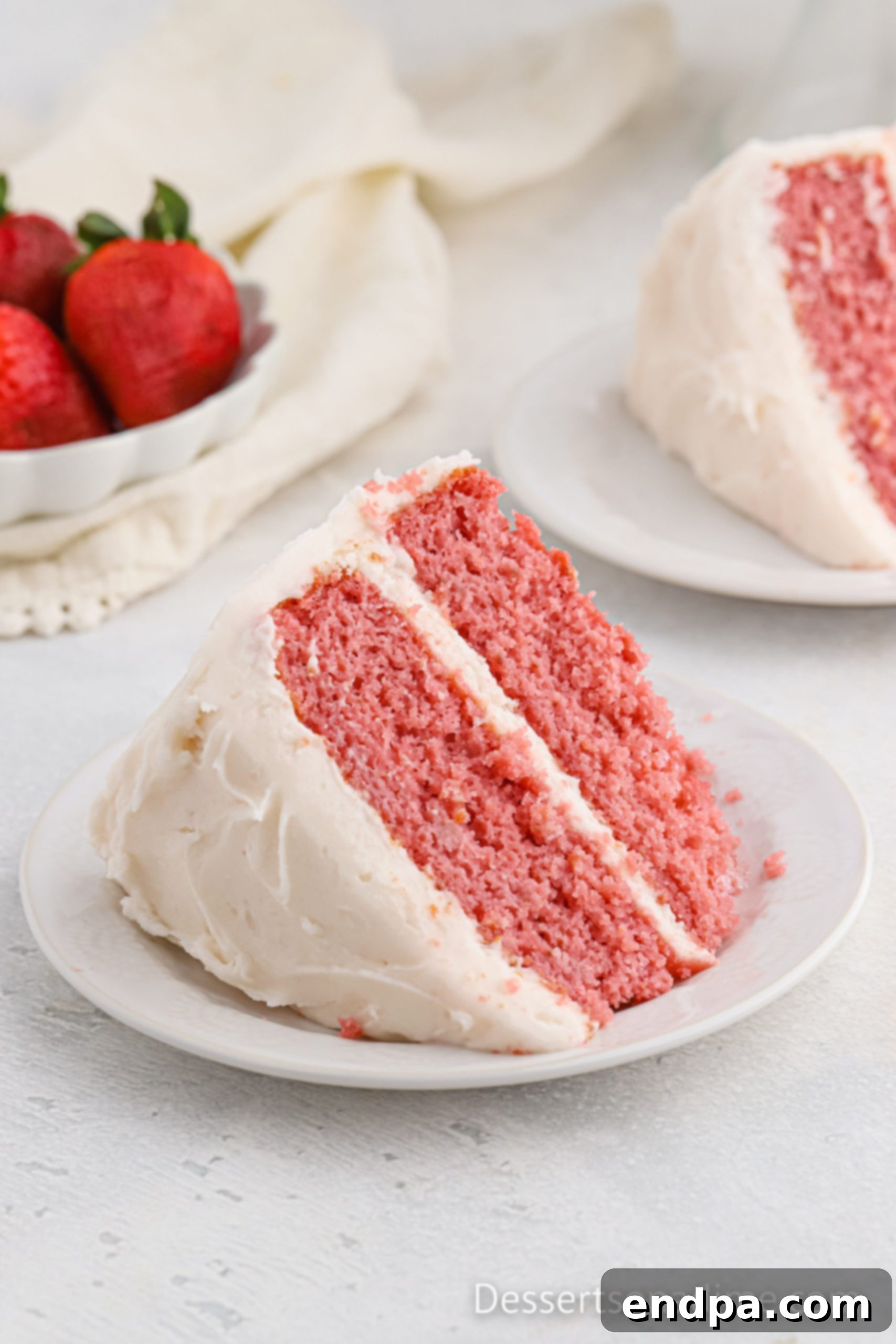 Paula Deen's Signature Strawberry Cake 2 A beautiful slice of Paula Deen Strawberry Cake on a white plate, showcasing its moist layers and creamy pink frosting.