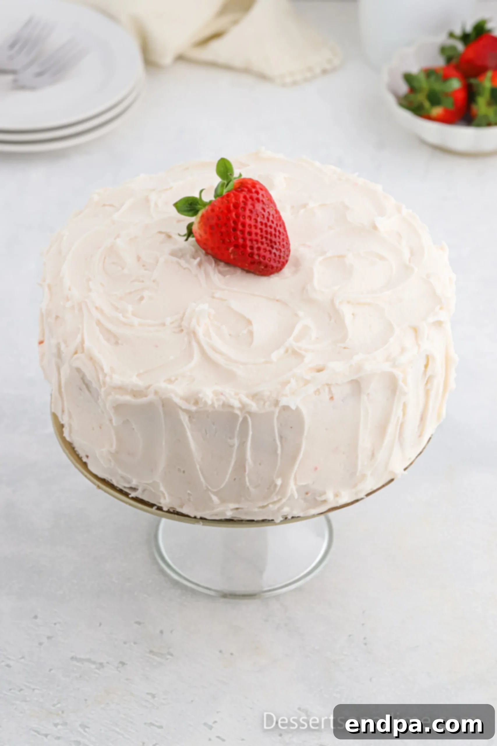 Paula Deen's Signature Strawberry Cake 12 A fully decorated Paula Deen Strawberry Cake, frosted and ready to serve, displayed beautifully on a cake stand.